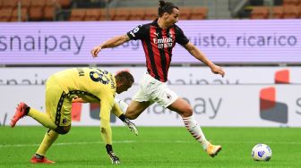 Penyerang AC Milan, Zlatan Ibrahimovic (kanan) memperebutkan bola dengan kiper Bologna Lukasz Skorupski selama pertandingan sepak bola Serie A Italia AC Milan melawan Bologna di Stadion San Siro, Milan, Italia, Selasa (22/9) dini hari WIB. [MIGUEL MEDINA / AFP]