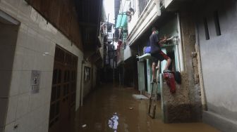 Warga beraktivitas di rumahnya yang terendam banjir di kawasan Kebon Pala, Kampung Melayu, Jakarta, Selasa (22/9/2020). [Suara.com/Angga Budhiyanto]