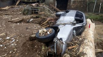 Kondisi mobil yang terbawa arus pasca banjir bandang di Kampung Cibuntu, Desa Pasawahan, Kecamatan Cicurug, Sukabumi, Jawa Barat, Selasa (22/9/2020). [ANTARA FOTO/Yulius Satria Wijaya]
