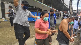 Anggota BNN mengawal tersangka usai melakukan penggerebekan di Palembang, Sumatera Selatan, Selasa (22/9/2020).  [ANTARA FOTO/R.M. Amri Ramdhani]