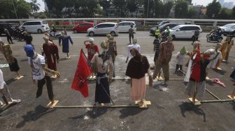 Puluhan boneka jerami atau orang-orangan sawah yang dipasang oleh massa Komite Nasional Pembaruan Agraria (KNPA) saat menggelar aksi Hari Tani Nasional  di depan gedung DPR RI, Jakarta, Kamis (24/9/2020). [Suara.com/Angga Budhiyanto]