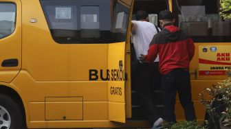 Pasien tanpa gejala COVID-19 memasuki bus sekolah yang dioperasikan Dinas Perhubungan DKI Jakarta yang mengantar dari Puskesmas Kecamatan Makassar, Jakarta, Kamis (24/9/2020). [Suara.com/Angga Budhiyanto]