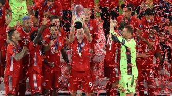 Para pemain Bayern Muenchen mengangkat trofi setelah pertandingan sepak bola Piala Super UEFA antara FC Bayern Muenchen dengan Sevilla di Puskas Arena, Hongaria, Jumat (25/9) dini hari WIB. [Laszlo Szirtesi / POOL / AFP]