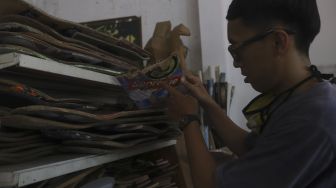 Reynanto Akhmad Aditya (35) memilah papan skateboard yang akan dibuat kacamata kayu di workshopnya di kawasan Kramat Jati, Jakarta, Jumat (25/9/2020). [Suara.com/Angga Budhiyanto]