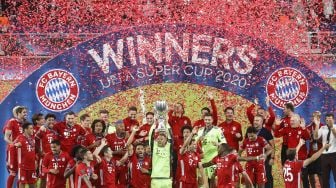 Para pemain Bayern Muenchen mengangkat trofi setelah pertandingan sepak bola Piala Super UEFA antara FC Bayern Muenchen dengan Sevilla di Puskas Arena, Hongaria, Jumat (25/9) dini hari WIB. [Laszlo Szirtesi / POOL / AFP]