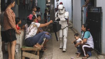 Super hero ngamen keliling kampung di Kawasan Tapos, Depok, Jawa Barat, Minggu (27/9/2020). [ANTARA FOTO/Asprilla Dwi Adha]