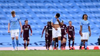 Gelandang Manchester City Kevin De Bruyne (kiri), gelandang Manchester City Rodri (tengah) dan bek Manchester City Nathan Ake (kanan) tertunduk lesu usai timnya kebobolan selama selama pertandingan sepak bola Liga Premier Inggris antara Manchester City melawan Leicester City di Etihad Stadium, Manchester, Minggu (27/9/2020).  [Laurence Griffiths / POOL / AFP]
