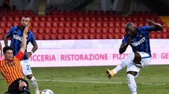 Penyerang Inter Milan Romelu Lukaku (kanan) melakukan tembakan untuk mencetak gol keduanya pada pertandingan sepak bola Serie A Italia Benevento melawan Inter Milan di Stadion Ciro Vigorito, Benevento, Italia, Rabu (30/9). [Tiziana FABI / AFP]