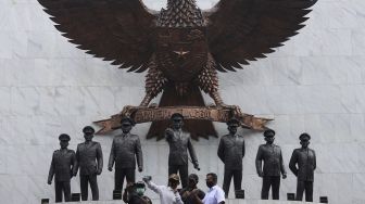 Pengunjung berswafoto di depan Monumen Pancasila Sakti di Lubang Buaya, Jakarta, Kamis (1/10/2020). [Suara.com/Angga Budhiyanto]