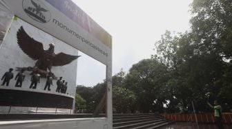 Petugas Dinas Kehutanan memotret Monumen Pancasila Sakti di Lubang Buaya, Jakarta, Kamis (1/10/2020). [Suara.com/Angga Budhiyanto]