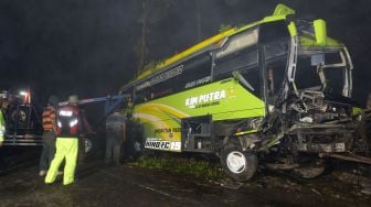 Sejumlah polisi bersama warga berusaha mengevakuasi bangkai bus pariwisata bernopol K 1446 BL yang mengalami kecelakaan di jalur Dieng-Wonosobo Desa Kuripan, Garung, Wonosobo, Jawa Tengah, Rabu (30/9/2020). [ANTARA FOTO/Anis Efizudin]