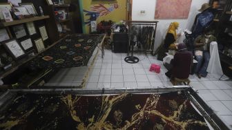 Perajin menyelesaikan proses pembuatan motif batik di Rumah Batik Palbatu, Jakarta, Jumat (2/10/2020). [Suara.com/Angga Budhiyanto]