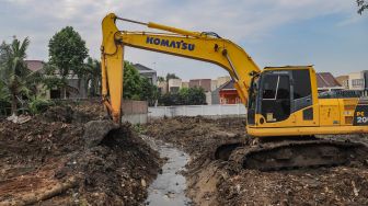 Alat berat digunakan untuk mengeruk material tanah dalam proses pembangunan Waduk Pilar Jati di Cipinang Melayu, Jakarta Timur,  Sabtu (3/10). [Suara.com/Alfian Winanto]