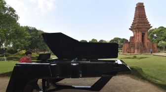 Pianis dan komponis Ananda Sukarlan memainkan piano Sjuman+Renanda yang mendapat rekor MURI untuk 'grand piano pertama buatan Indonesia' pada rangkaian konser Raspodia Nusantara dan Kejayaan Nusantara di Candi Gapura Bajang Ratu, Trowulan, Mojokerto, Jawa Timur, Sabtu (3/10/2020). [ANTARA FOTO/Zabur Karuru]