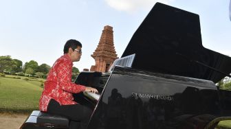 Pianis dan komponis Ananda Sukarlan memainkan piano Sjuman+Renanda yang mendapat rekor MURI untuk 'grand piano pertama buatan Indonesia' pada rangkaian konser Raspodia Nusantara dan Kejayaan Nusantara di Candi Gapura Bajang Ratu, Trowulan, Mojokerto, Jawa Timur, Sabtu (3/10/2020). [ANTARA FOTO/Zabur Karuru]