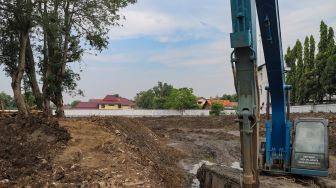 Alat berat digunakan dalam proses pembangunan Waduk Pilar Jati di Cipinang Melayu, Jakarta Timur, Sabtu (3/10). [Suara.com/Alfian Winanto]