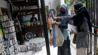 Warga menimbang sampah plastik untuk digunakan sebagai pembayaran minuman tradisional di kafe Ecobrick Jalan R.A Kartini, Kabupaten Jombang, Jawa Timur, Jumat (2/10/2020). [ANTARA FOTO/Syaiful Arif]
