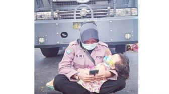 Viral Foto Polwan Jaga Kantor Bawaslu Sambil Mengasuh Anaknya