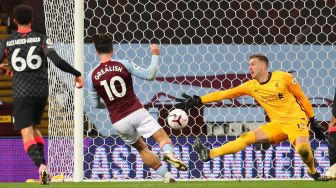 Gelandang Aston Villa Jack Grealish (tengah) mencetak gol ketujuh mereka usai melewati kiper Liverpool Adrian selama pertandingan sepak bola Liga Premier Inggris antara Aston Villa melawan Liverpool di Villa Park, Birmingham, Inggris, Senin (5/10) dini hari WIB. [Catherine Ivill / POOL / AFP]
