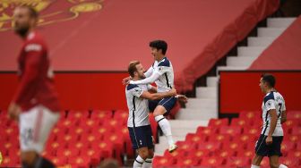 Striker Tottenham Hotspur Korea Son Heung-Min (tengah) melompat memeluk striker Tottenham Hotspur Harry Kane (kiri) setelah ia mencetak gol kedua mereka selama pertandingan sepak bola Liga Premier Inggris antara Manchester United melawan Tottenham Hotspur di Old Trafford, Manchester, Inggris, Minggu (4/10).  [Oli SCARFF / AFP]