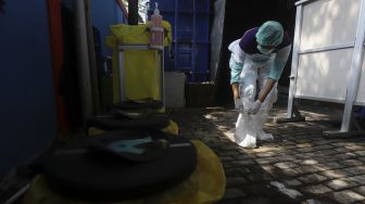 Petugas medis melepas baju hazmat sebelum membersihkan diri (dekontaminasi) usia bertugas menangani pasien COVID-19 di Puskesmas Kecamatan Gambir, Jakarta, Selasa (6/10/2020). [Suara.com/Angga Budhiyanto]