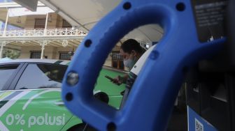 Pengemudi taksi online melakukan pengisian daya pada mobil listrik di Stasiun Pengisian Kendaraan Listrik Umum (SPKLU) di Kantor PLN Disjaya, Gambir, Jakarta, Selasa (6/10/2020). [Suara.com/Angga Budhiyanto]