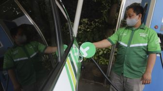 Pengemudi taksi online melakukan pengisian daya pada mobil listrik di Stasiun Pengisian Kendaraan Listrik Umum (SPKLU) di Kantor PLN Disjaya, Gambir, Jakarta, Selasa (6/10/2020). [Suara.com/Angga Budhiyanto]