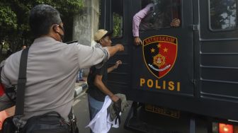 Aparat kepolisian menangkap seorang massa yang terlibat bentrokan di sekitar Gedung DPR RI, Jakarta, Rabu (7/10/2020). [Suara.com/Angga Budhiyanto]