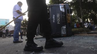 Mobil polisi yang dihancurkan oleh sejumlah massa aksi di kawasan Penjernihan, Jakarta, Rabu (7/10/2020). [Suara.com/Angga Budhiyanto]