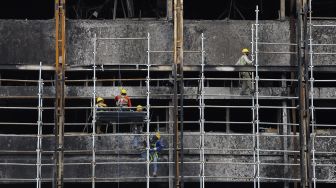 Pekerja memasang stager untuk perbaikan Gedung Kejaksaan Agung, Jakarta, Rabu (7/10/2020). [Suara.com/Angga Budhiyanto]