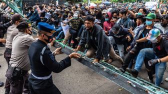 Massa gabungan dari buruh dan mahasiswa merobohkan pagar kompleks gedung DPRD Jateng saat berunjuk rasa menolak RUU Cipta Kerja Omnibus Law yang telah disahkan oleh DPR RI di depan gedung DPRD Jateng, Kota Semarang, Jawa Tengah, Rabu (7/10/2020). [ANTARA FOTO]