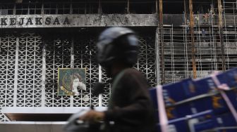 Pengendara sepeda motor melintas di depan Gedung Kejaksaan Agung, Jakarta yang tengah diperbaiki, Rabu (7/10/2020). [Suara.com/Angga Budhiyanto]