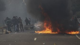 Pengunjuk rasa yang menolak pengesahan Undang-Undang Cipta Kerja membakar fasilitas umum di kawasan Patung Kuda, Jakarta, Kamis (8/10/2020). [Suara.com/Angga Budhiyanto] 