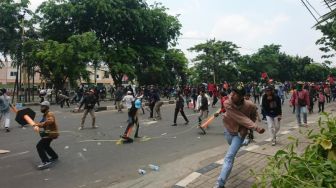 Massa menimpuki Polisi di Jalan Daan Mogot, Jakarta Barat, Kamis (8/10). [Suara.com/ Irfan Maulana]