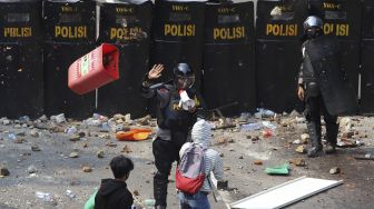 Bentrokan terjadi antara pengunjuk rasa yang menolak pengesahan Undang-Undang Cipta Kerja dengan polisi saat demonstasi di kawasan Patung Kuda, Jakarta, Kamis (8/10/2020). [Suara.com/Angga Budhiyanto]