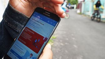 Penunjukkan aplikasi Peduli dan Lindungi untuk mendeteksi zona penyebaran COVID-19 di sekitar tempat tinggalnya di Perumahan Makmur Jaya, Drangong, Serang, Banten, Sabtu (10/10/2020).  [ANTARA FOTO/Asep Fathulrahman]