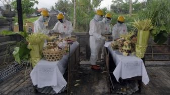 Petugas menggunakan pakaian hazmat dan alat pelindung diri saat melakukan proses kremasi jenazah pasien COVID-19 di Krematorium Sagraha Mandra Kantha Santhi, Desa Bebalang, Bangli, Bali, Sabtu (10/10/2020). [ANTARA FOTO/Nyoman Hendra Wibowo]