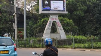 Coretan massa aksi demo tolak Omnibus Law Kamis (8/10) lalu di Tugu prakiraan cuaca yang masih belum dihapus di Jalan Merdeka Selatan, Jakarta Pusat, Sabtu (10/10). [Suara.com/Alfian Winanto]