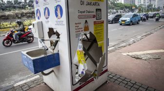 Pengendara melintasi fasilitas cuci tangan yang rusak imbas unjuk rasa menolak pengesahan Undang-Undang Cipta Kerja di Jalan Medan Merdeka Barat, Jakarta, Sabtu (10/10/2020). [ANTARA FOTO/Dhemas Reviyanto]