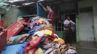 Warga melakukan evakuasi di salah satu rumah yang rusak berat akibat longsor di kawasan Ciganjur, Jagakarsa, Jakarta, Minggu (11/10/2020). [Suara.com/Angga Budhiyanto]