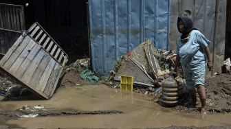 Warga melintas di depan rumah yang terdampak banjir bandang luapan Sungai Cipalebuh, Desa Mandalakasih, Pameungpeuk, Kabupaten Garut, Jawa Barat, Senin (12/10/2020). [ANTARA FOTO/Candra Yanuarsyah]