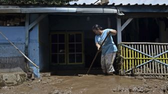 Warga membersihkan sisa lumpur dari banjir bandang luapan Sungai Cipalebuh, Desa Mandalakasih, Pameungpeuk, Kabupaten Garut, Jawa Barat, Senin (12/10/2020). [ANTARA FOTO/Candra Yanuarsyah]