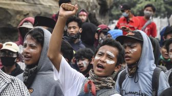 Anak di bawah umur mengikuti aksi tolak UU Cipta Kerja di kawasan Patung Kuda, Jakarta, Selasa (13/10/2020).   [ANTARA FOTO/Muhammad Adimaja]