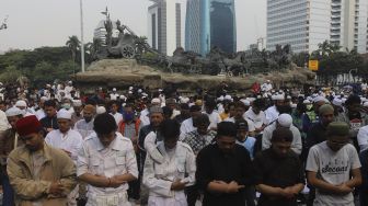 Sejumlah massa dari Persaudaraan Alumni (PA) 212 dan sejumlah ormas Islam melaksanakan Shalat Ashar berjamaah disela-sela menggelar aksi unjuk rasa di kawasan Patung Kuda, Jakarta, Selasa (13/10/2020). [Suara.com/Angga Budhiyanto]