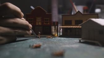 Tristan Saputra (36) menyelesaikan pembuatan miniatur tiga dimensi atau diorama di Khals Miniatur, Otista 3 Raya, Jakarta, Rabu (14/10/2020). [Suara.com/Angga Budhiyanto]