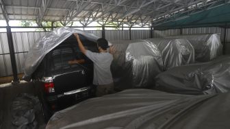 Teknisi merawat kendaraan milik nasabah di Gudang Terpadu Pegadaian, Kebon Nanas, Jakarta, Kamis (15/10/2020). [Suara.com/Angga Budhiyanto]