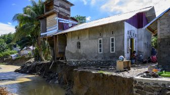 Warga duduk di depan rumahnya yang nyaris ambruk diterjang banjir akibat luapan sungai di Desa Lumbudolo, Kecamatan Banawa Tengah, Kabupaten Donggala, Sulawesi Tengah, Jumat (16/10/2020). [ANTARAFOTO/Basri Marzuki]