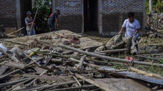 Warga mengumpulkan barang-barang dari rumahnya yang ambruk diterjang banjir akibat luapan sungai di Desa Lumbudolo, Kecamatan Banawa Tengah, Kabupaten Donggala, Sulawesi Tengah, Jumat (16/10/2020). [ANTARAFOTO/Basri Marzuki]