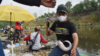 Sejumlah orang memancing ikan lele secara gratis di Sungai Madiun, Kota Madiun, Jawa Timur, Minggu (18/10/2020).   [ANTARA FOTO/Siswowidodo]
