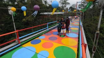 Sejumlah pengunjung berfoto saat mengunjungi Jembatan Polkadot Merapi di Klakah, Selo, Boyolali, Jawa Tengah, Sabtu (17/10/2020).  [ANTARA FOTO/Aloysius Jarot Nugroho]
